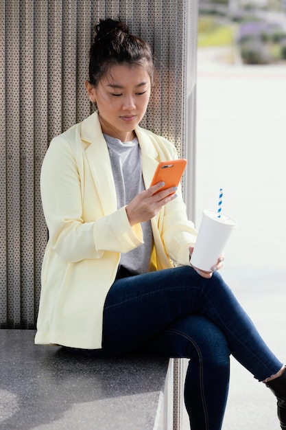 コーヒーを楽しんで屋外で若い女性