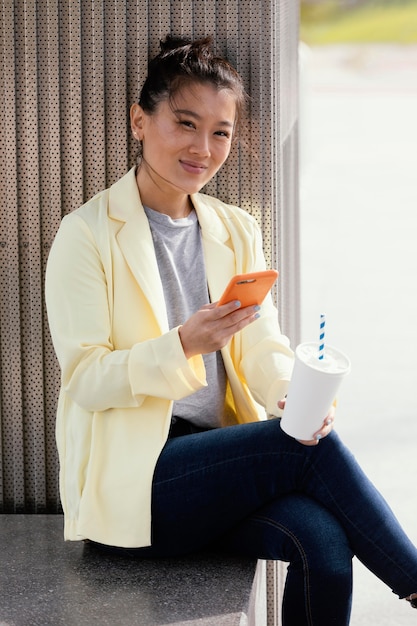 Giovane donna all'aperto che gode della tazza di caffè