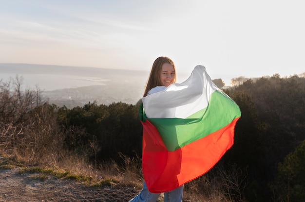 Young woman outdoors holding the bulgarian flag