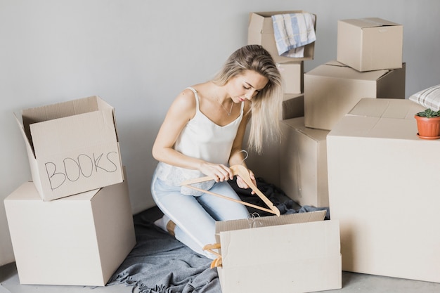 Free photo young woman packing coat hanger