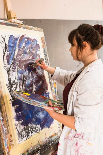 페인트 브러시와 캔버스에 그림 젊은 여자