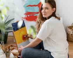 Foto gratuita giovane donna pittura con acrilici a casa