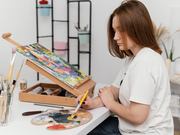 アクリル絵の具で絵を描く若い女性