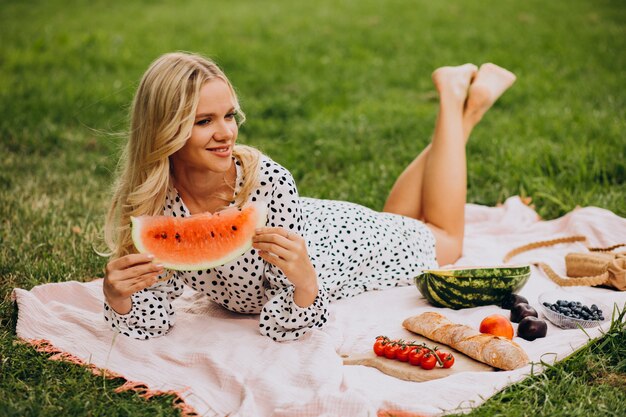 Free photo young woman in park eating watermelon