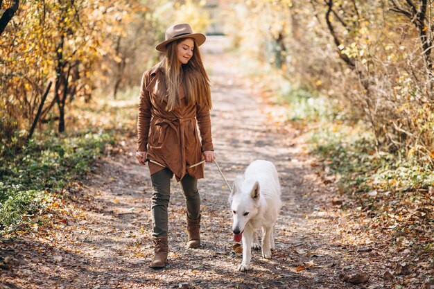 Young woman in park with her white dog