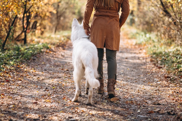 Foto gratuita giovane donna nel parco con il suo cane bianco