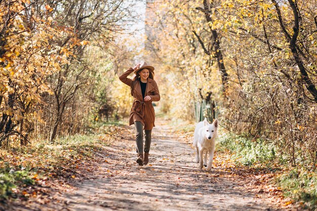 Young woman in park with her white dog