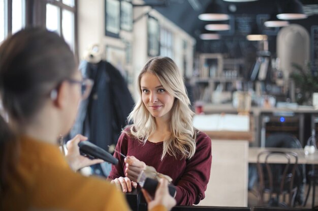 young woman pays by credit card in a restaurant