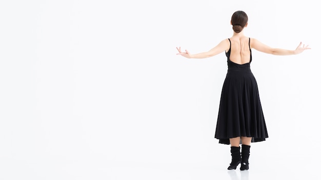 Бесплатное фото Молодая женщина исполняет балет с копией пространства