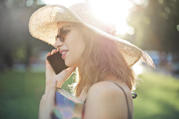 Free photo young woman on the phone in a park