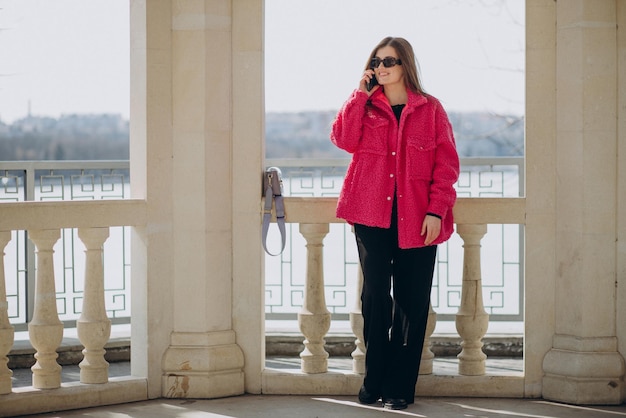 Young woman in pink coat standing in the street