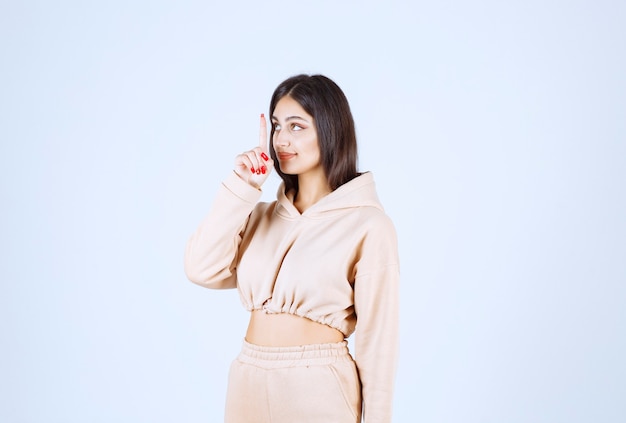 Young woman in a pink hoodie asking for silence