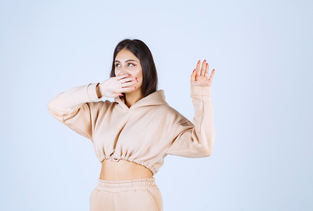 Free photo young woman in a pink hoodie caughing and has sore throat