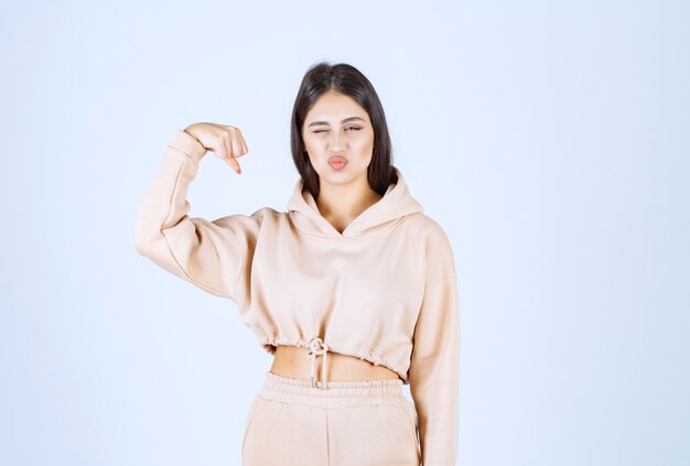 Young woman in a pink hoodie feeling strong and powerful