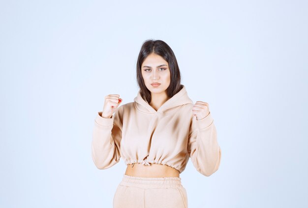 Young woman in a pink hoodie feeling strong and powerful