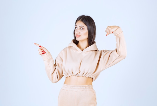 Young woman in a pink hoodie feeling strong and powerful