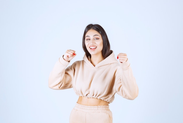 Young woman in a pink hoodie feeling strong and powerful