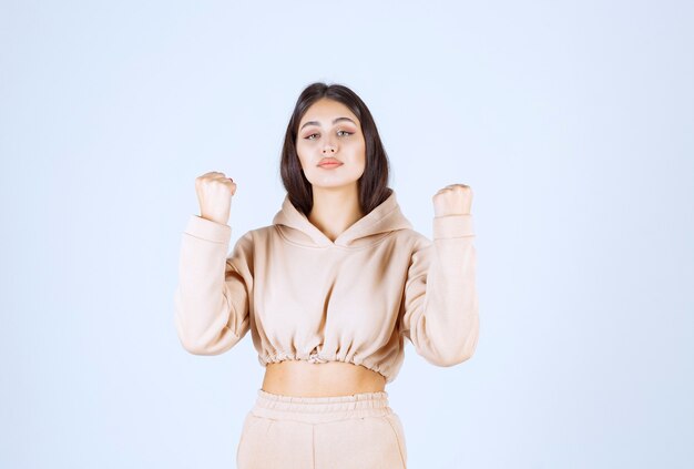 Young woman in a pink hoodie feeling strong and powerful