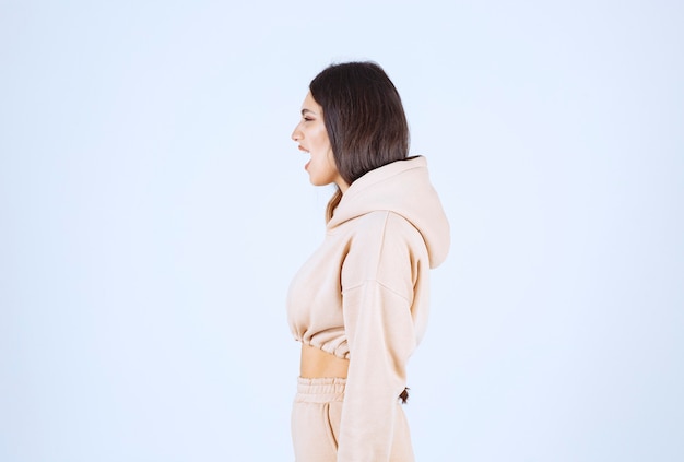 Free photo young woman in a pink hoodie frightened and scared