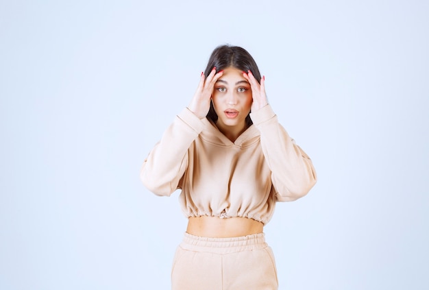 Young woman in a pink hoodie frightened and scared