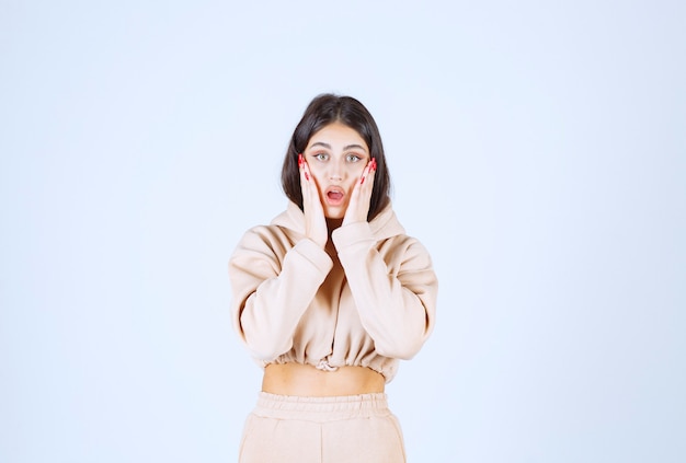 Young woman in a pink hoodie frightened and scared