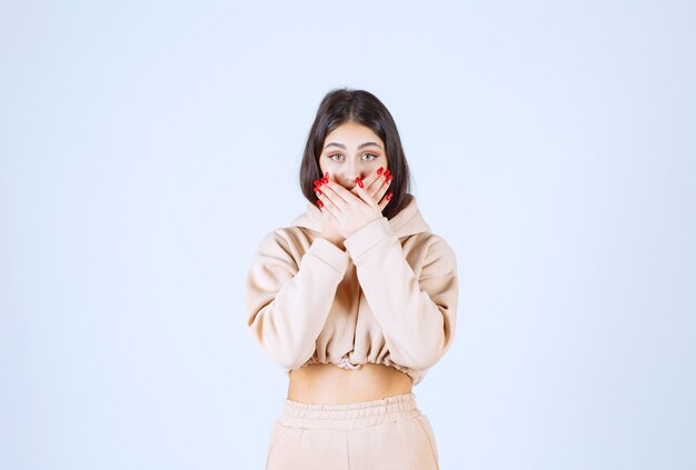 Young woman in a pink hoodie frightened and scared