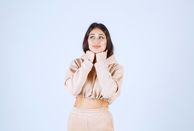 Young woman in a pink hoodie giving lovely and heartful poses