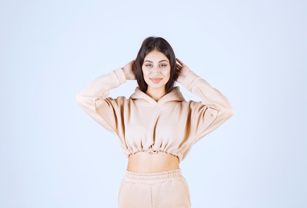 Young woman in a pink hoodie giving neutral poses