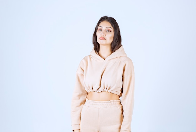 Young woman in a pink hoodie giving neutral poses