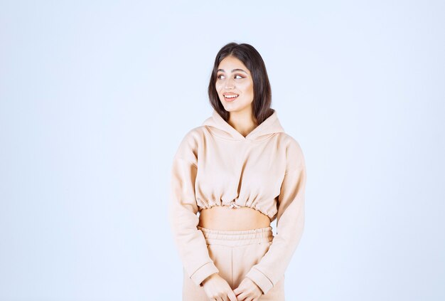 Young woman in a pink hoodie giving neutral poses