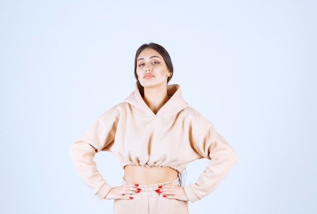 Young woman in a pink hoodie giving neutral poses
