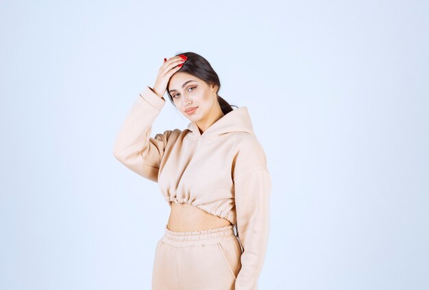 Young woman in a pink hoodie giving neutral poses