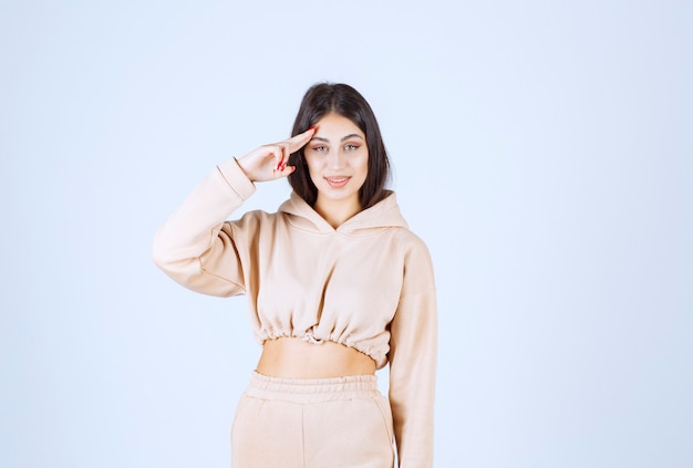 Young woman in a pink hoodie greeting someone