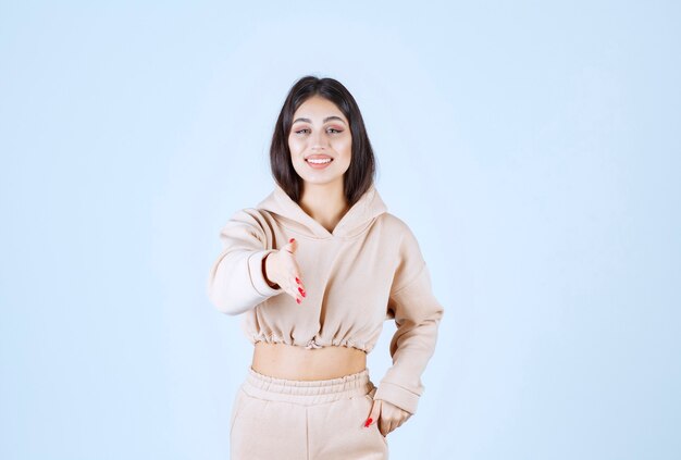 Young woman in a pink hoodie greeting someone