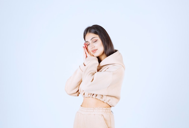 Young woman in a pink hoodie looks tired and sleepy