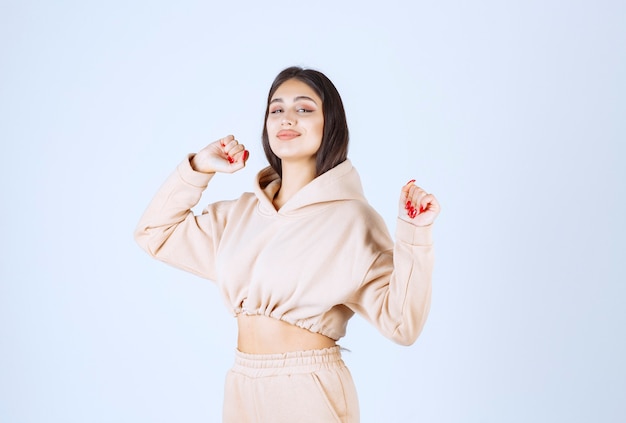 Young woman in a pink hoodie looks tired and sleepy