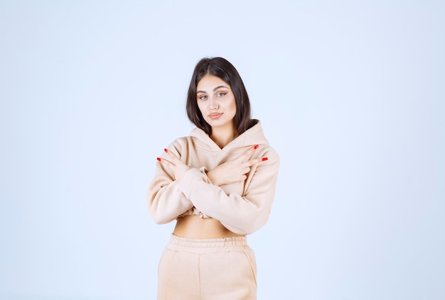 Young woman in a pink hoodie pointing both sides