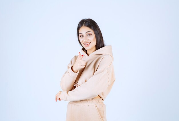 Young woman in a pink hoodie pointing the person in front of her