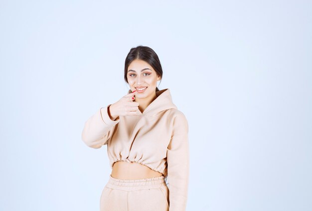 Young woman in a pink hoodie pointing the person in front of her