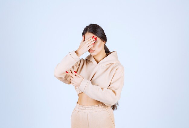 Young woman in a pink hoodie pointing something on the left