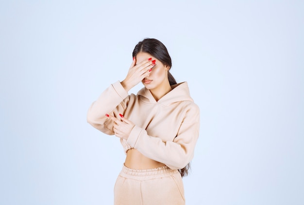 Young woman in a pink hoodie pointing something on the left