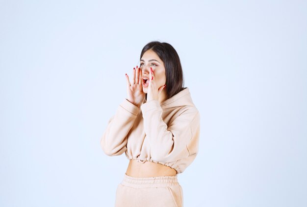 Young woman in a pink hoodie shooting out loud