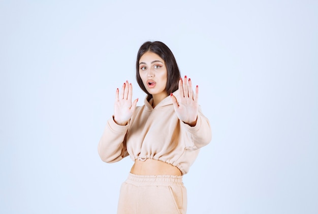 Young woman in a pink hoodie stopping an undesirable thing