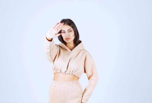 Young woman in a pink hoodie stopping an undesirable thing