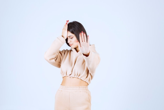 Free photo young woman in a pink hoodie stopping an undesirable thing