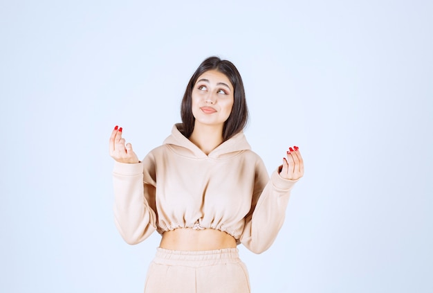 Young woman in a pink hoodie uniting hands and praying