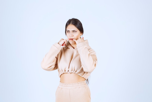 Young woman in a pink hoodie whistling