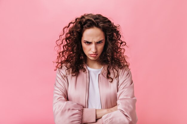 Young Woman in pink jacket sulking on isolated background