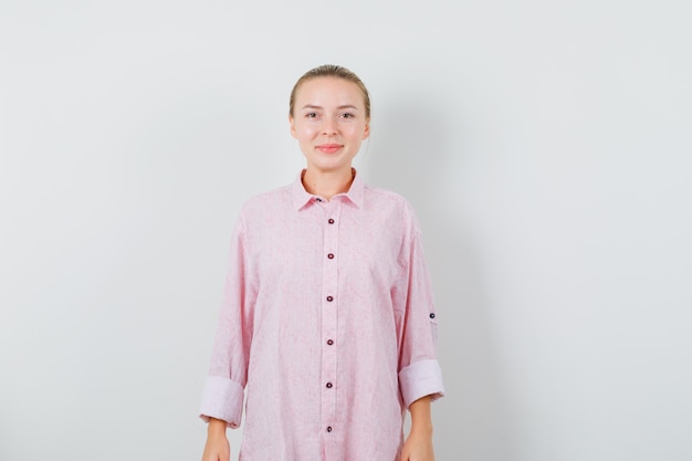 Young woman in pink shirt looking and looking happy