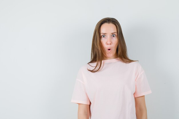 Young woman in pink t-shirt and looking surprised.